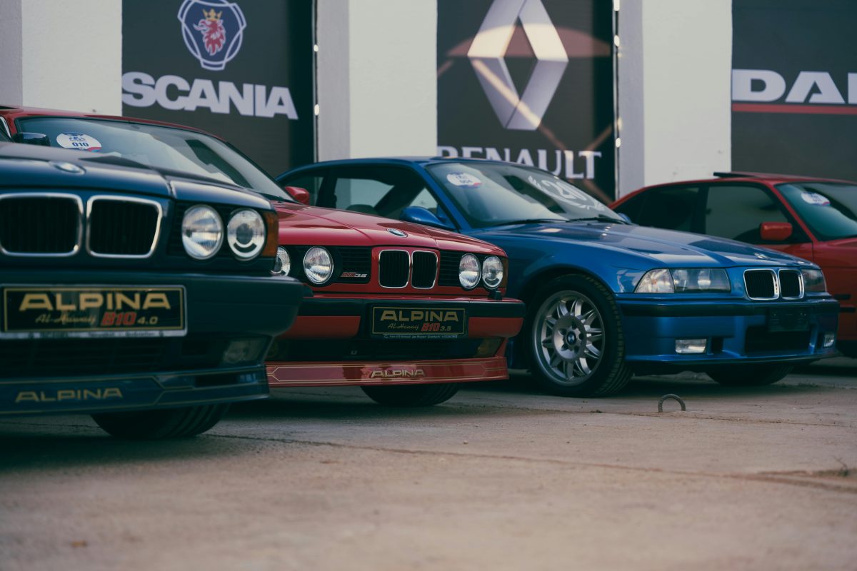 A lineup of modern classic cars including BMW E30 and Alpina B10, representing the golden era of analog driving that deserves a Joyeauto wireless CarPlay retrofit to bridge the digital gap without ruining the factory dashboard.